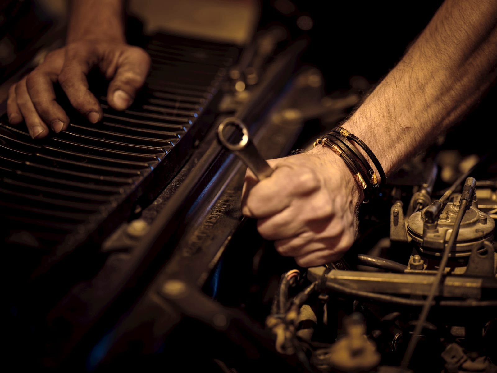 Manos de un mecánico realizando el mantenimiento del motor de un coche