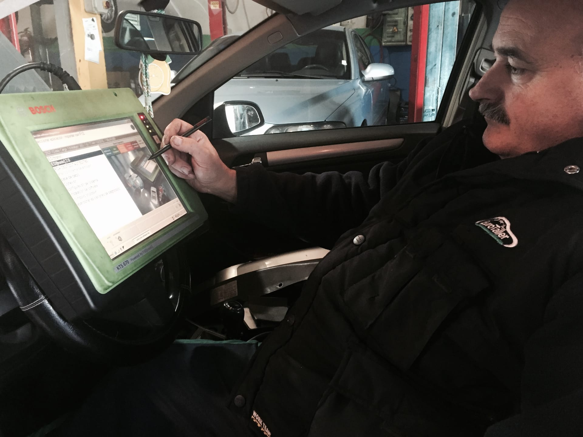 Técnico realizando una diagnosis electrónica Bosch dentro de un vehículo